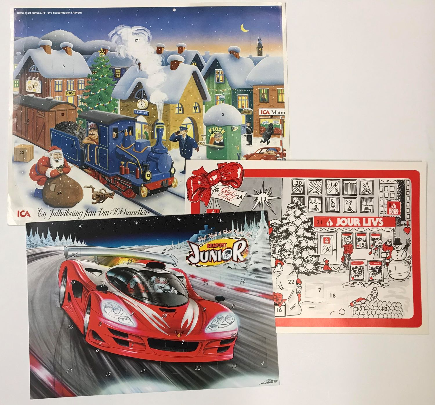 Överst en julkalender från ICA som visar en vintrigt stad med ett tåg, till höger en julkalender från Jour Livs med matbutiken i centrum samt en från tidskriften Bilsport Junior med en röd sportbil i centrum, som körs av tomten