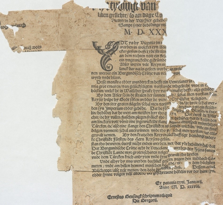 Färgfoto av ett mycket slitet och trasigt tryckt ark där endast delar av den svarta tryckta texten återstår.