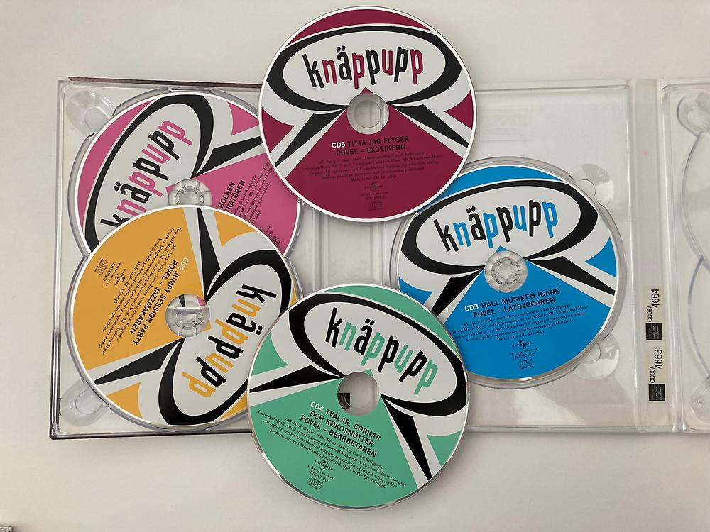 Fem cd-skivor med färgglada Knäppupp-etiketter.