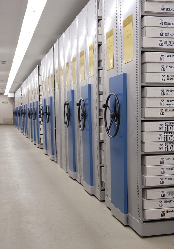 Shelves with books in a row, each with a large wheel.