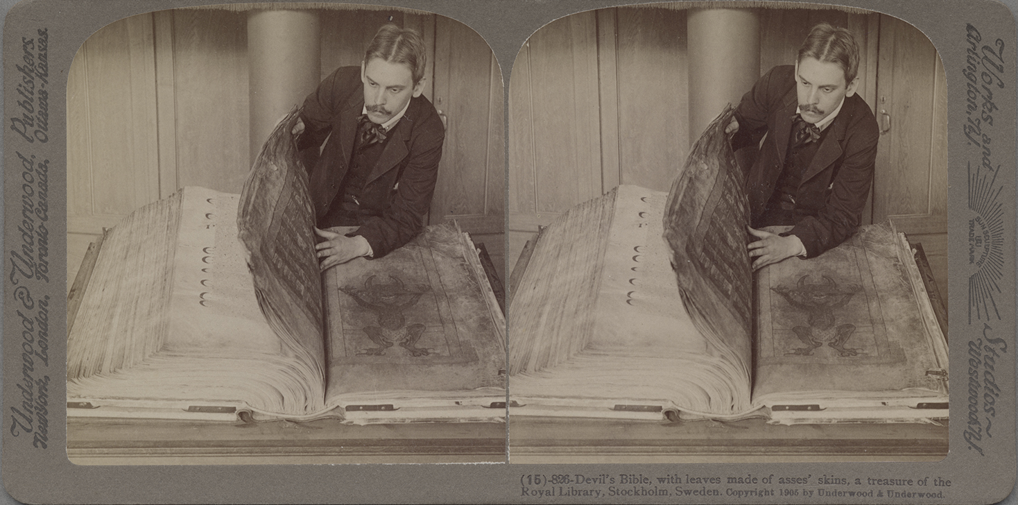 A black and white photo of a man that browses through the Codex Gigas.