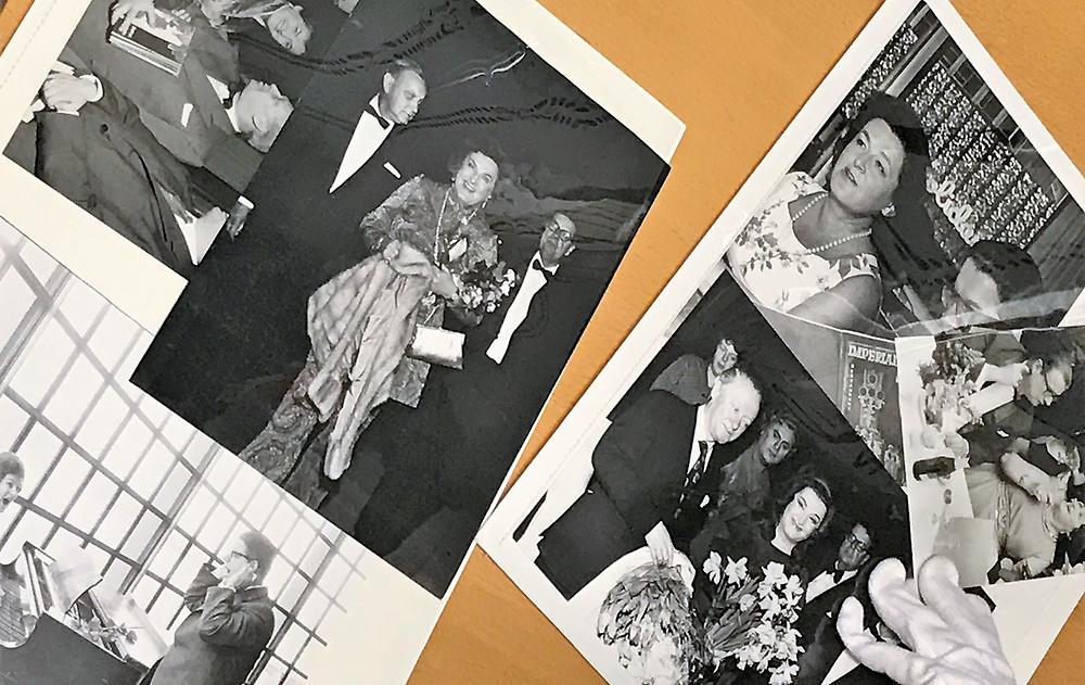 En hand i bomullsvante hanterar visningsmappar med fotografier föreställande Birgit Nilsson