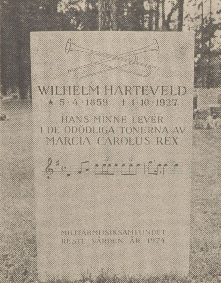 Bild på minnessten med korslagda trumpeter. Text: Wilhelm Harteveld.
