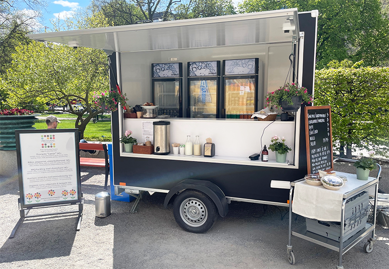 Vagn med öppen lucka där det bland annat syns skåp för drycker, kaffetermos och mjölkflaskor.