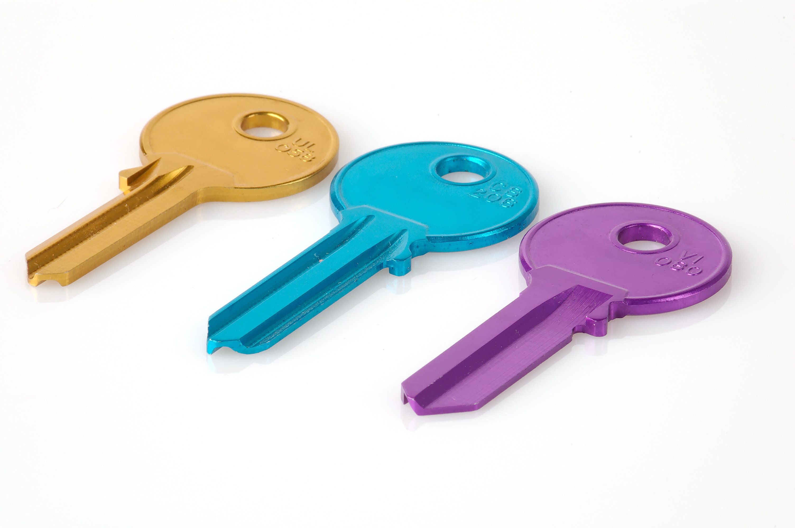 Three keys, yellow, blue and purple, on a white surface.