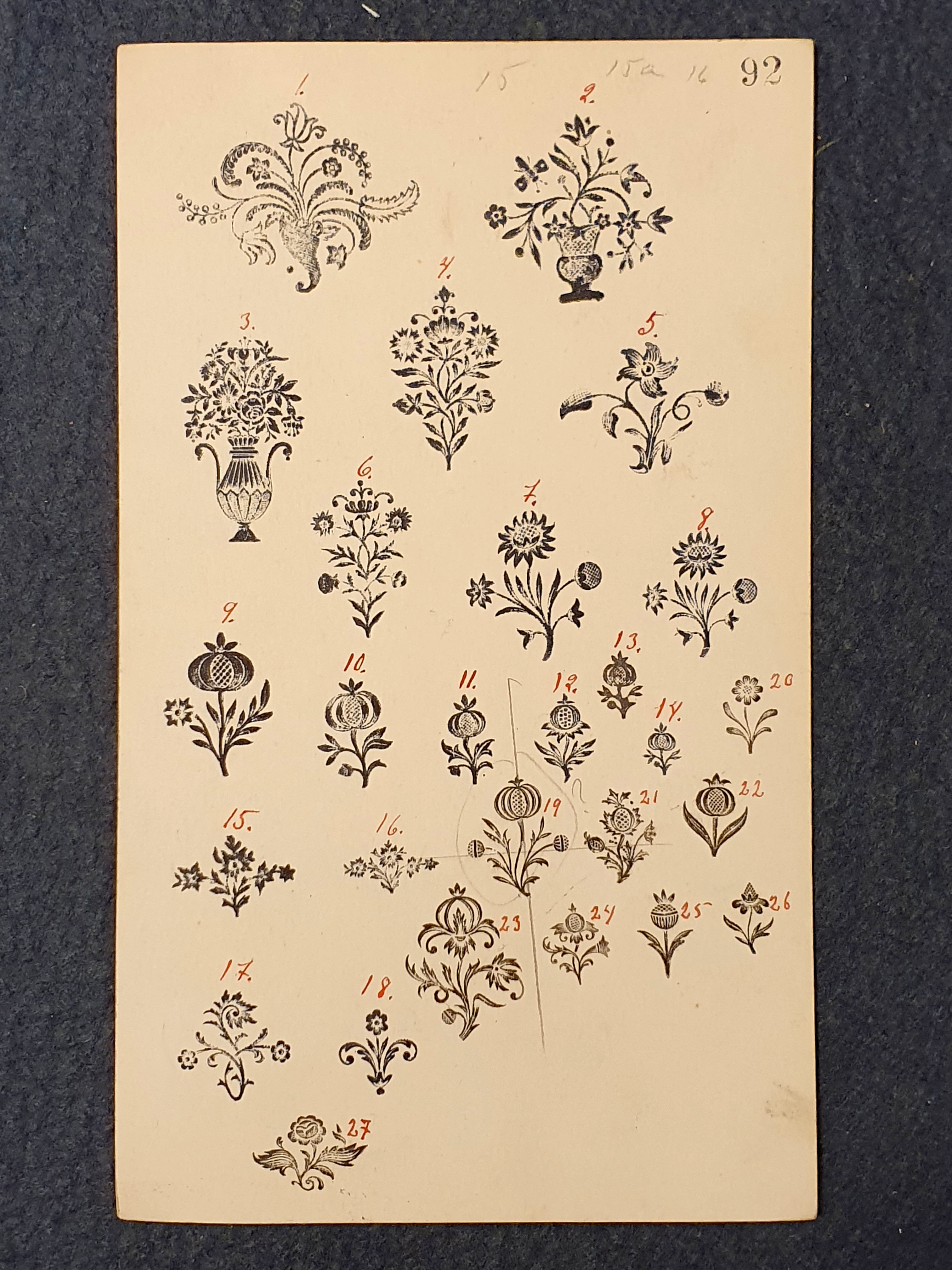 Foto av registerkort med avdrag i svart färg av förgyllningsstämplar med blomstermotiv. Kortet har en tryckt numrering "92". Blomstermotiven är numrerade för hand med röd penna.
