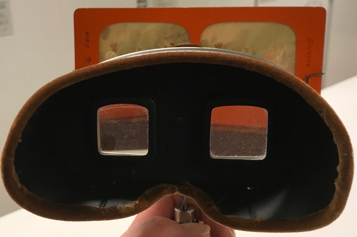 Ett stereoskop med de två titthålen i centrum. Bakom skymtar den isatta stereobilden.
