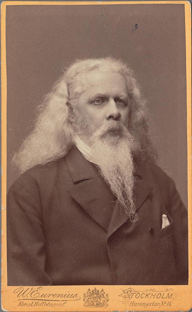 Bröstbild av en man med långt vitt hår och skägg.