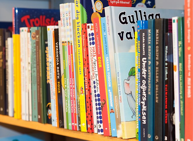 Barnböcker uppställda i en bokhylla. 