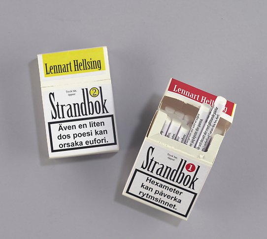 Två konstböcker, gjorda för att efterlikna cigarettpaket med författarnamn och varningstext. I dem finns hoprullade papper med text. 