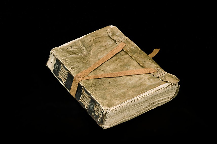 En äldre bok inslagen i beige skinn.