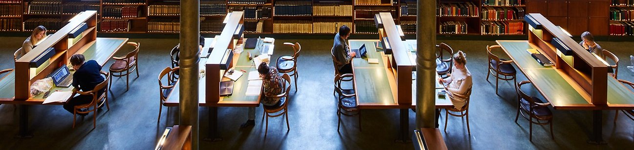 Foto snett uppifrån över en läsesal med personer som sitter och läser.