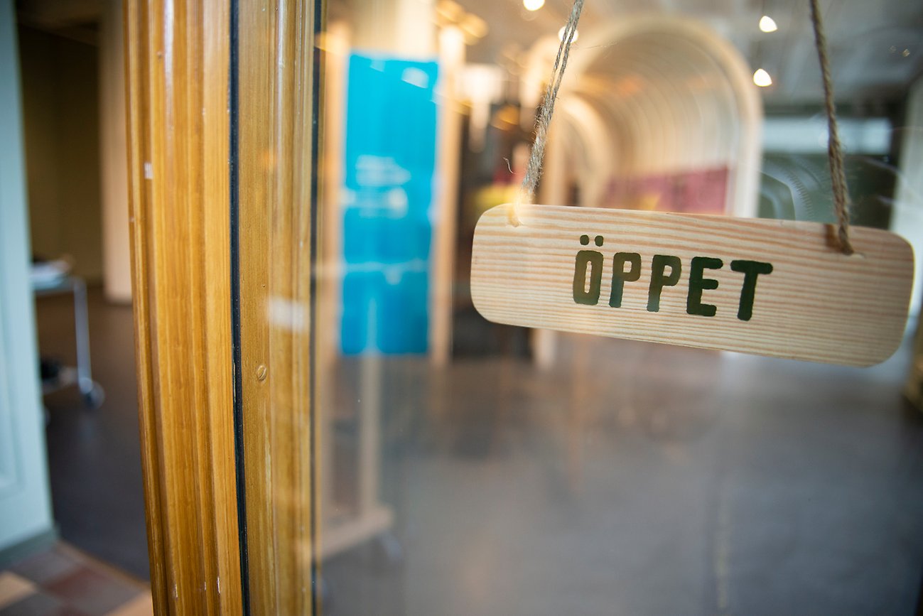 En träskylt med texten "öppet".