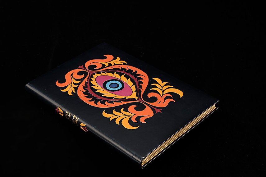 Bok i svart med ett färgglatt mönster som påminner om ett öga eller möjligen ett kvinnligt könsorgan.