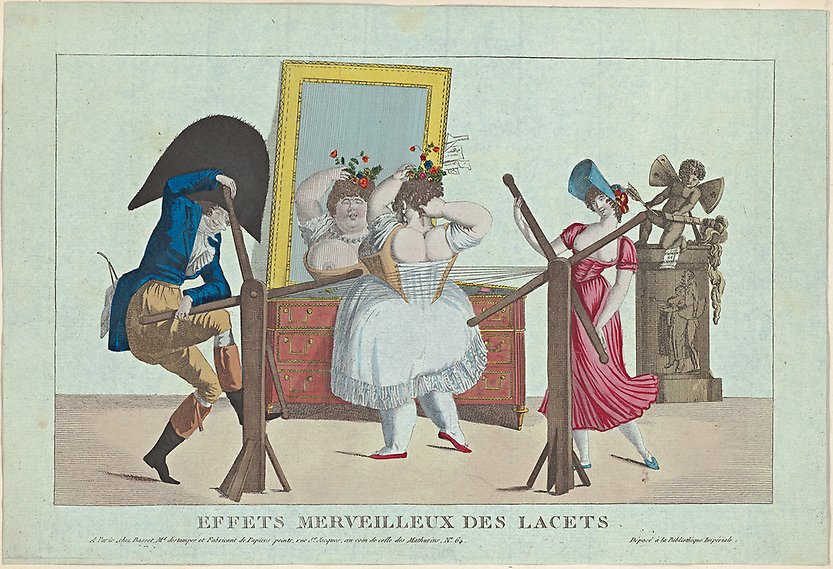 En rundlagd kvinna står i underklänning framför en spegel. Två personer drar åt hennes korsett med en slags träanordning så att ena bröstet trillar ut.