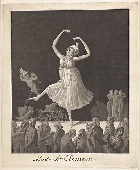 En kvinna i klänning och turban dansar på tå med benet i luften och armarna ovanför huvudet. Endast ett fåtal i publiken tittar upp på scenen.
