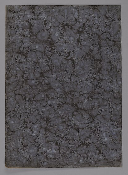 Foto av pappersark dekorerat med marmoreringsteknik.