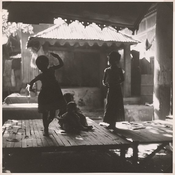 Barn dansar på ett bord i ett mörkt rum